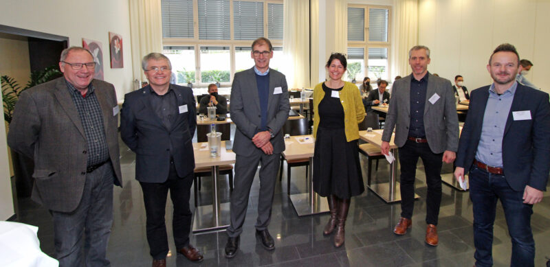 Fünf Männer und eine Frau stehen im Halbkreis - Kick-off zum Netzwerk Grüne Fernwärme