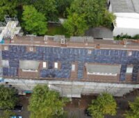 Ein Wohnblock mit PV auf dem Dach aus der Vogelperspektive