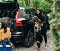 Zu sehen ist netzdienliches Laden von Elektroautos in einem Foto mit Kindern.