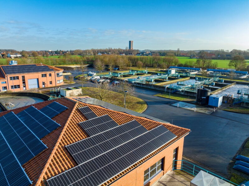 Luftbild einer Kläranlage mit Wasserbecken und PV auf den Gebäuden.