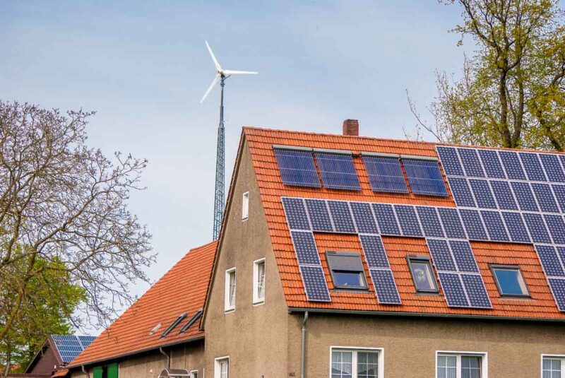 Kleinwindkraftanlage im Hintergrund eine Photovoltaik-Daches