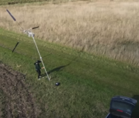 ein Mensch baut die mobile Kleinwindkraft-Anlage auf.