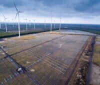 Windpark im Flachland mit den Grundkonstruktionen für große Solarparks.