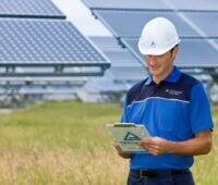 Zu sehen ist ein Mitarbeiter vom TÜV Rheinland in einem Solarpark. Das Wissen über klimaabhängige Erträge von Photovoltaik-Modulen ist wichtig für die Solarbranche.