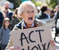 Frau mit Pappschild "Act now" - Symbol für Klimaklage von BUND und SFV.