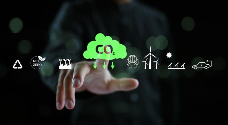 Grafik zeigt grüne Wolke mit Schriftzug CO2, eine Hand, verschiedene Icons für Sektoren