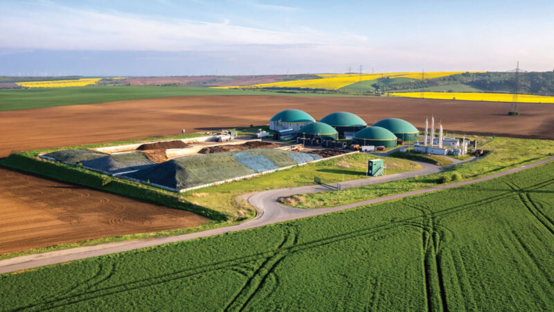 Biogasanlage in einer offenen Landschaft mit Ackerflächen