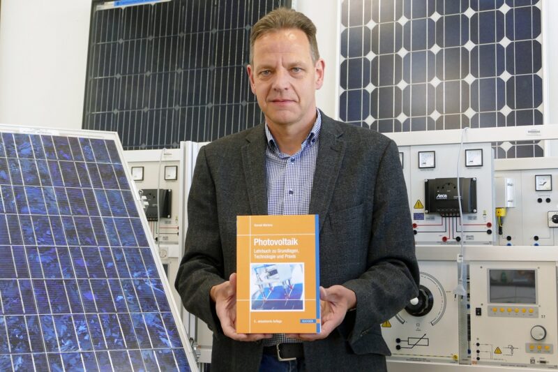 Zu sehen ist Prof. Dr. Konrad Mertens mit seinem Photovoltaik-Lehrbuch.