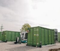 Mehre grüne Batteriecontainer unter freiem Himmel.