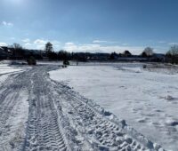 Zu sehen sind Baggerspuren im Schnee auf der Baustelle vom Photovoltaik-Solarpark „Altes Kraftwerk“ in Zschornewitz.
