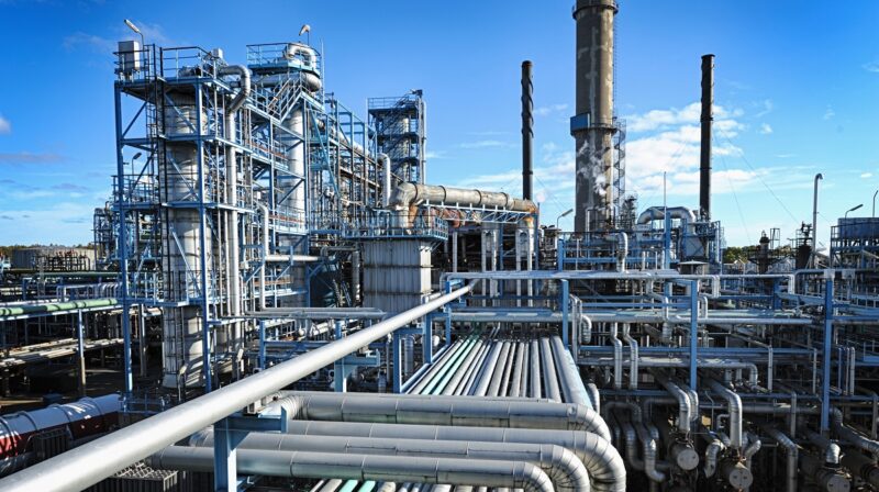 Zu sehen ist ein Industriekomplex mit Öl- und Gasleitungen. Nachhaltige Wärmeerzeugung in Industrie- und Gewerbegebieten mit Solarthermie, Wärmepumpen und anderen Erneuerbaren Energien ist eine große Herausforderung.