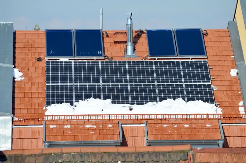 Zu sehen ist ein winterliches Dach mit Photovoltaik und Solarthermie. Mit dem Solarkataster in Baden-Württemberg können Bürger:innen die Wirtschaftlichkeit berechnen.