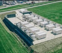 Luftbild eines Großspeichers mit einem Dutzend Containern und rund 50 Besuchern.