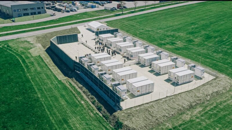 Luftbild eines Großspeichers mit einem Dutzend Containern und rund 50 Besuchern.