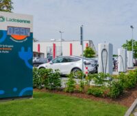 Ladestation für Solarstrom neben parkenden E-Fahrzeuegn.