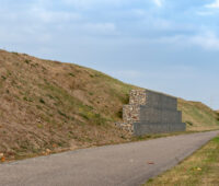 Ein Lärmschutz-Wall, an dessen Fuß ein Radweg verläuft - keine Photovoltaik-Anlage.