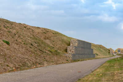 Ein Lärmschutz-Wall, an dessen Fuß ein Radweg verläuft - keine Photovoltaik-Anlage.