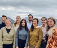 Gruppenbild mit sechs Frauen und zwei Männern auf Hügel vor einem Flusstal - das neue Team von Landwärme für die CO2-Vermarktung.