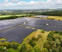 Freiflächensolarpark auf grüner Wise im Flachland.