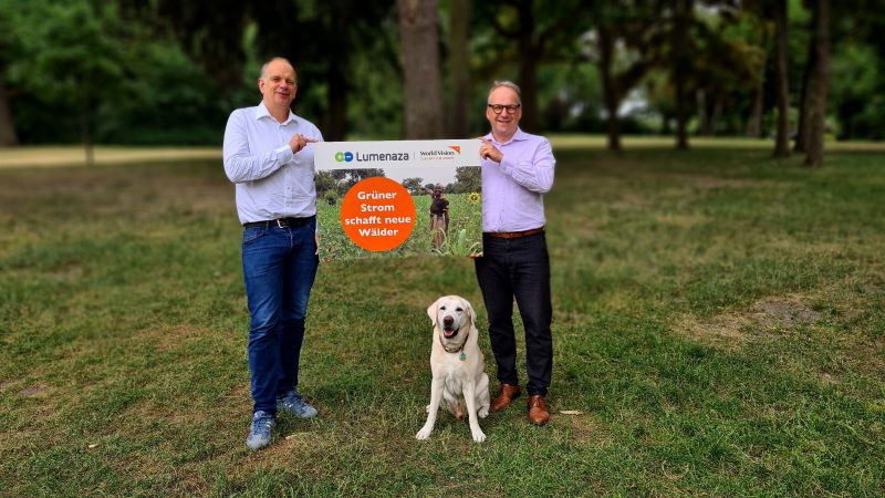 Christoph Waffenschmidt, Vorstandsvorsitzender von World Vision Deutschland (rechts), und Christian Chudoba, CEO bei Lumenaza halten ein Schild.