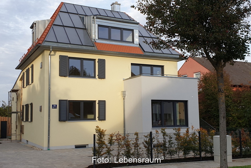 Ein Mehrfamilienhaus mit einer Solarthermieanlage auf dem Spitzdach.