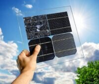 Zu sehen ist eine Hand, die verschiedene Solarzellen in die Sonne hält. Solarzellen aus ferroelektrischen Kristallen könnten eine Alternative zur Silizium-Solarzelle sein, die heutzutage in den meisten Photovoltaik-Modulen zum Einsatz kommt.