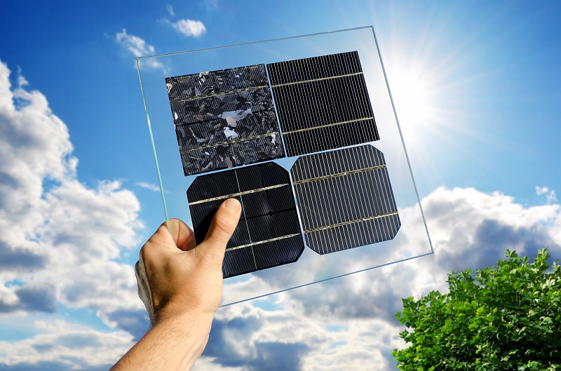 Zu sehen ist eine Hand, die verschiedene Solarzellen in die Sonne hält. Solarzellen aus ferroelektrischen Kristallen könnten eine Alternative zur Silizium-Solarzelle sein, die heutzutage in den meisten Photovoltaik-Modulen zum Einsatz kommt.