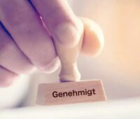 Im Bild ein Stempel mit der Aufschrift „genehmigt“ als Symbol für das Transformationsprogramm NRW.Bank.Invest Zukunft.