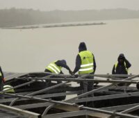 Bauarbeiter installieren eine Floating-Photovoltaik-Anlage, Agri-PV und Floating-PV erhalten Mittel aus dem Programm progres.nrw.