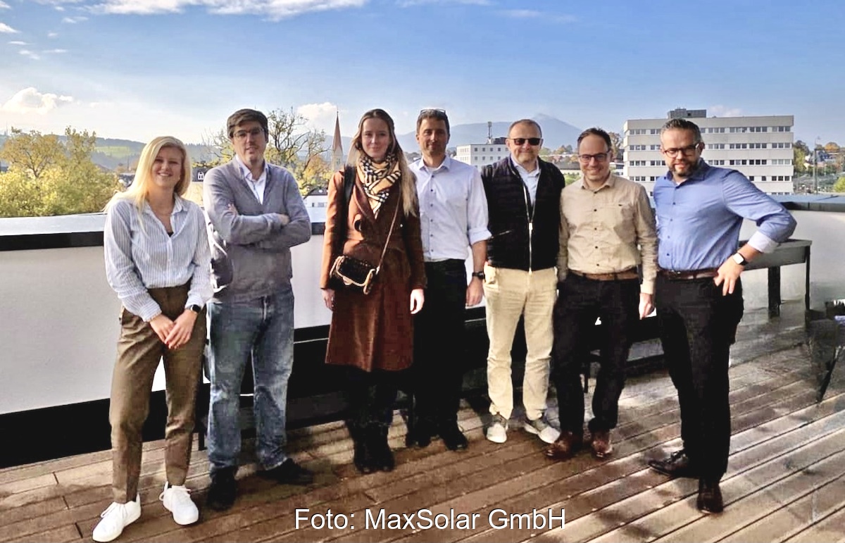 Die Verantwortlichen stehen gemeinsam auf dem Dach eines Hochhauses mit Stadt und blauem Himmel im Hintergrund und freuen sich über die BESS-Partnerschaft zwischen MaxSolar und Greenvolt Power.