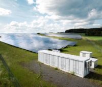 KI generierte Simulation zeigt PV-Freiflächenanlage mit einem Batteriespeicher.