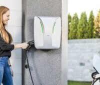 Eine Frau steckt das Ladekabel ihres Autos an die Hardy-Barth-Wallbox, diese enthält nun das HEMS von Solar Manager.