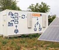 Ein Batteriespeicher neben Solarmodulen, in Österreich gibt es eine Diskussion um Netzentgelte für Batteriespeicher.