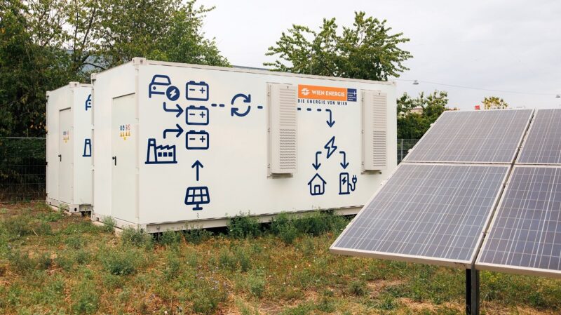 Ein Batteriespeicher neben Solarmodulen, in Österreich gibt es eine Diskussion um Netzentgelte für Batteriespeicher.