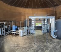 Ein runder Raum, darin eine Reihe von technischen Anlagen mit der Meerwasser-Wärmepumpe.
