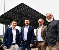 Vier Männer vor PV-Carport.