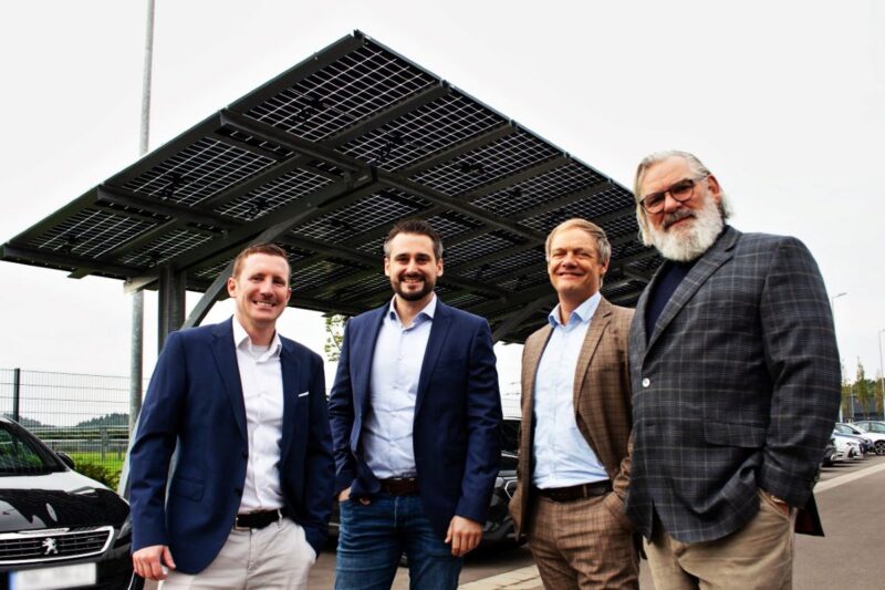 Vier Männer vor PV-Carport.