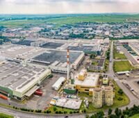 Luftbild eines großen Reifenwerks mit Industriehallen und Photovoltaik auf dem Dach