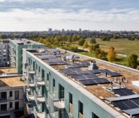 Photovoltaik-Anlage auf großem Gebäude-Komplex mit Gründach von oben fotografiert - Mieterstromprojekt in Berlin.