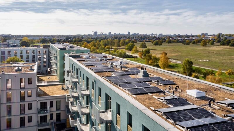 Photovoltaik-Anlage auf großem Gebäude-Komplex mit Gründach von oben fotografiert - Mieterstromprojekt in Berlin.