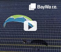 Bild mit Paraglider, der auf einer PV-Freiflächen Anlage landet