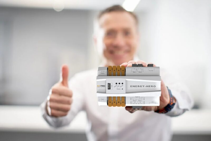 Person hält Smart-Meter-Gerät in der Hand mit Daumen hoch.