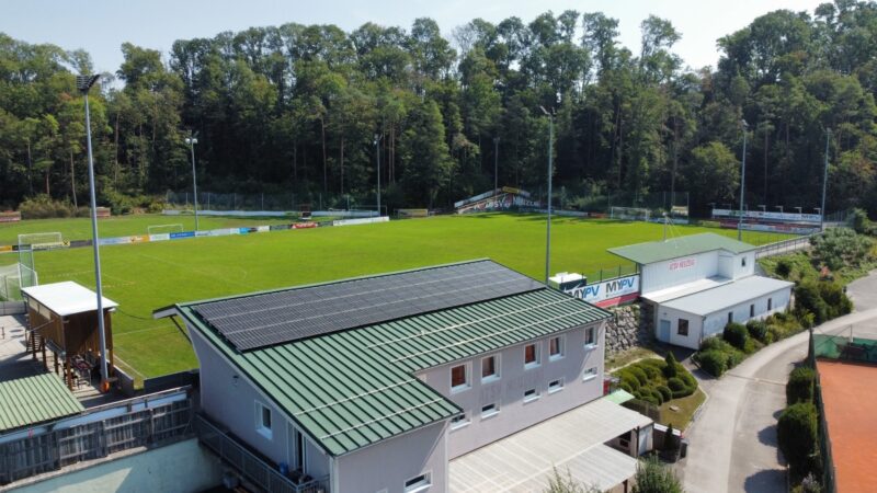 Vereinsheim an einem Fußballfeld mit PV-Anlage auf dem Dach.
