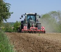 Zu sehen ist ein Traktor bei der Aussaat der Blühwiesen als Substrat für Biogas-Anlagen.