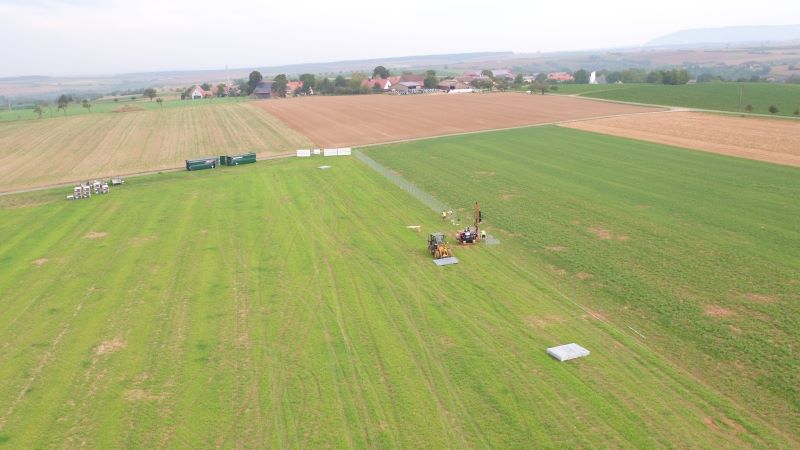 Grüne Wisen udn Acker mit Baufahrzeugen