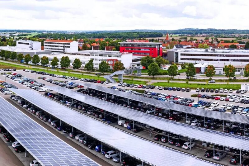 Zu sehen ist ein mit PV-Modulen überdachter Firmenparkplatz mit hunderten von Parkplätzen. Die Photovoltaik-Pflicht für neue Parkplätze in NRW soll ab 35 Stellplätzen greifen.