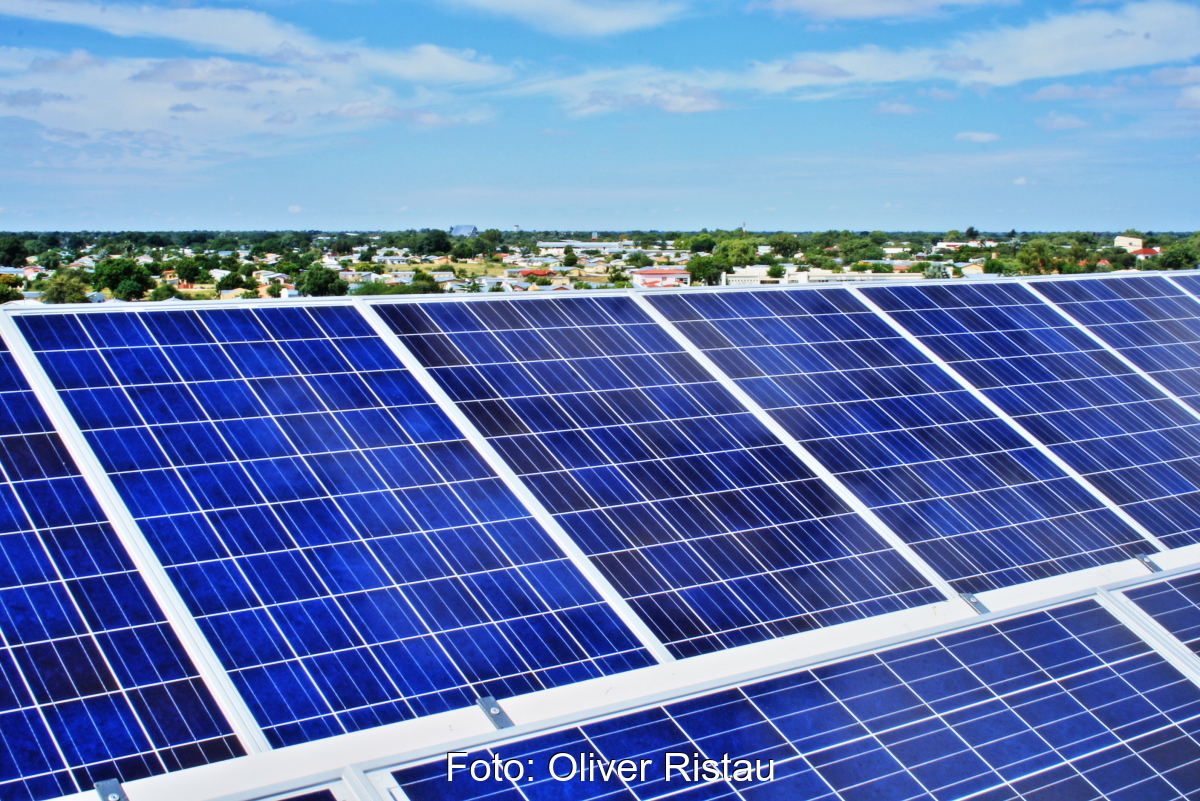 PV-Module auf dem Dächer - im Horizont südwestafrikanische Landschaft