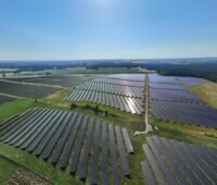 Luftbild eines 70 MW-Freiflächen-Solarparks bei Sonnenschein.