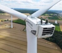 Zwei Mitarbeiter auf einer Gondel einer Naturstrom-Windanlage.