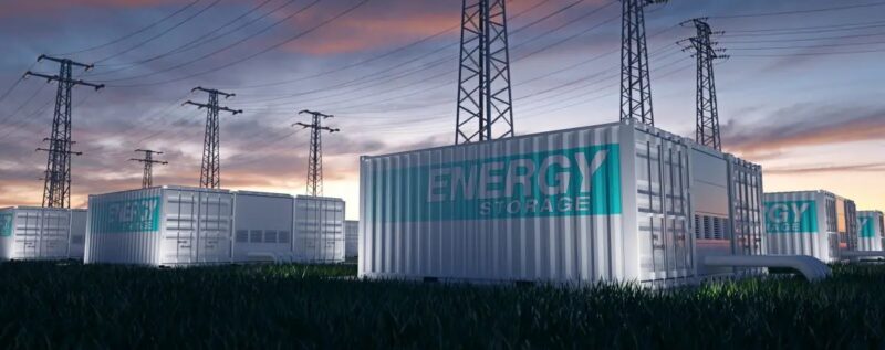 Großbatterien in Containern vor Stromleitungen, die Netzdienlichkeit von Großbatterien ist heute schon gegeben.